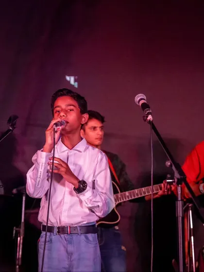 From young vocalists to seasoned guitarists, our showcase brings everyone together. Here, a student takes the lead vocal, backed by his bandmates.