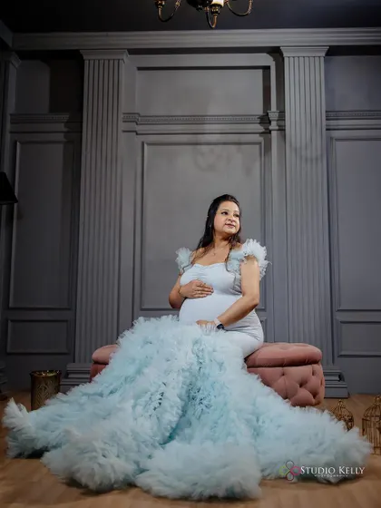 An ethereal maternity shot with the client in a flowing light blue gown. The makeup is soft and dreamy, complementing the angelic vibe of the photo.