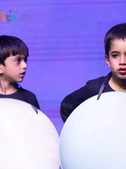 Two boys dressed as planets look at each other during their performance. The camaraderie and focus of our young actors is wonderful to witness.