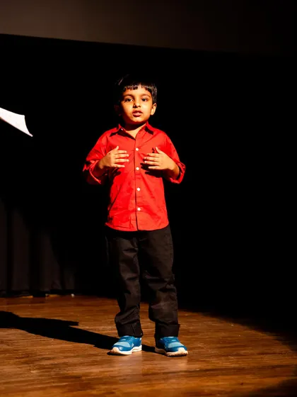 A young actor under a spotlight, showing the courage it takes to stand alone on stage and perform.