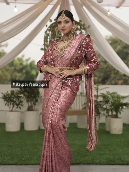 A full-length shot showcasing the entire look. The regal pose and beautiful setting highlight the elegance of the makeup and styling.