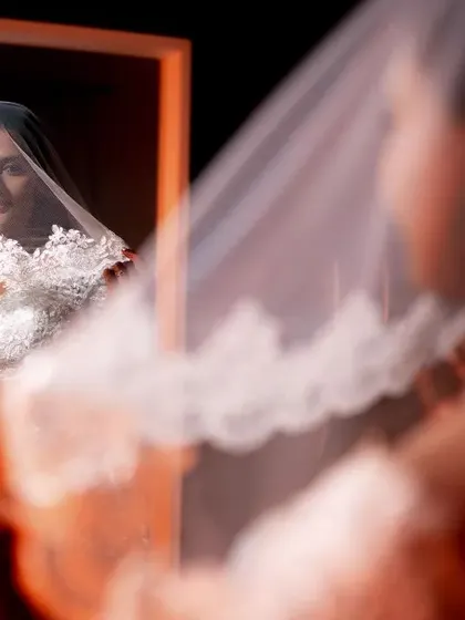 A beautiful bridal portrait, capturing the bride's reflection in a mirror as she adjusts her veil.