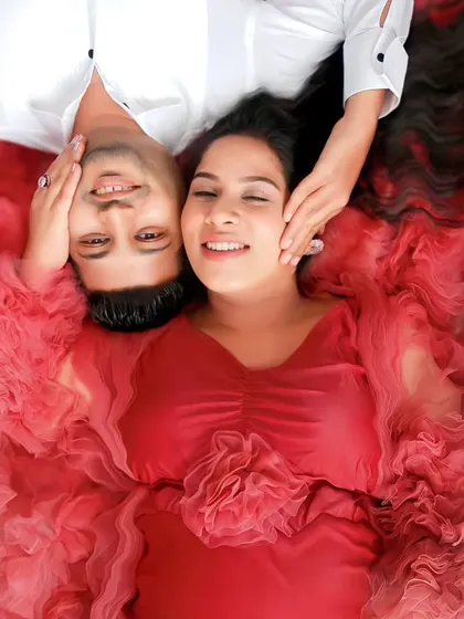 A creative top-down shot showing how the ruffled layers of this red gown create a beautiful floral-like effect. It's a unique option for artistic pre-wedding or maternity photos.