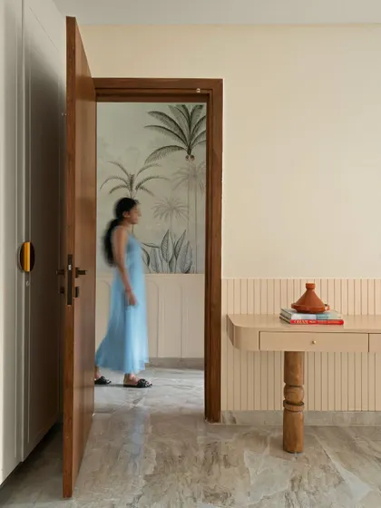A person walks past the open door of the master bedroom, giving a sense of movement and life to the beautifully designed home.