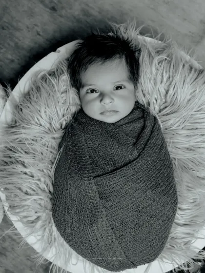 A striking black and white portrait. This simple, swaddled pose becomes incredibly powerful in monochrome, highlighting the baby's beautiful eyes and features.