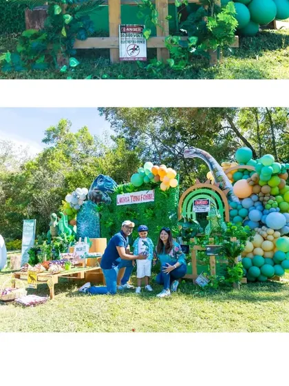 The happy family posing for a photo in front of the complete dinosaur party setup.