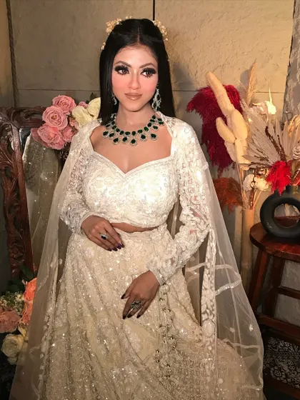 A full view of the sophisticated white lehenga look. The makeup is polished and refined, perfect for a reception or cocktail party.
