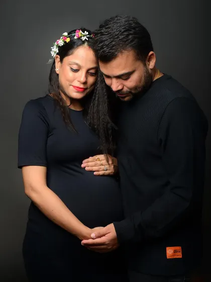 A quiet, downward glance at the belly captures a moment of reflection and deep connection between the couple and their unborn child.