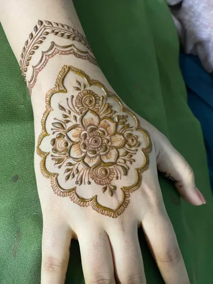 A beautiful and clean floral motif on the back of the hand with a simple wristband. It's elegant and doesn't require full coverage.