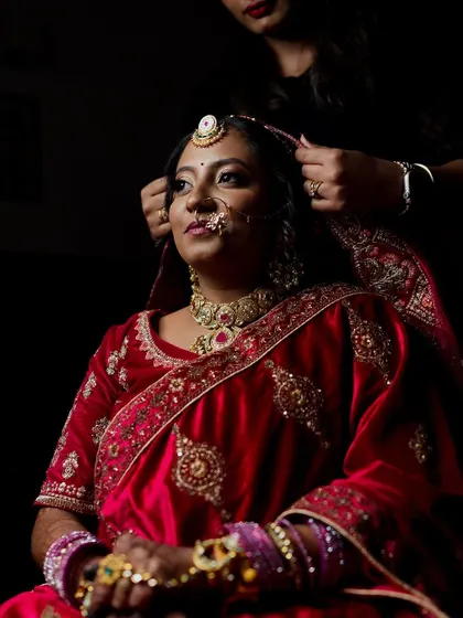 A getting-ready shot of a Marwadi bride as her dupatta is placed on her head. This is a moment of transformation that we are honored to capture.