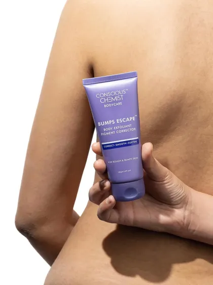 This shot focuses on the product in context. The model holds the body exfoliant against her back, suggesting its use case in a subtle and aesthetic way. The clean white background keeps it from being distracting.