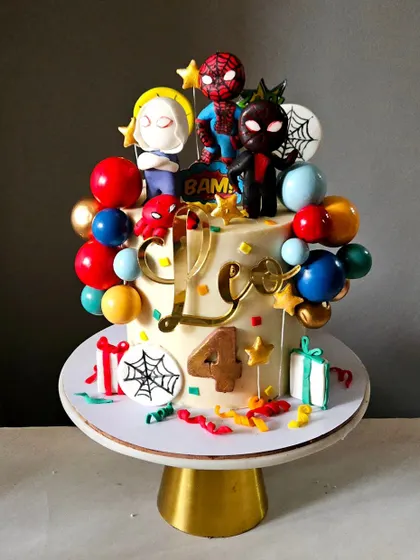 A festive Spider-Man cake perfect for a young superhero fan. This design is loaded with colorful balloons, presents, and multiple Spider-Verse characters, creating a dynamic and action-packed celebration cake.