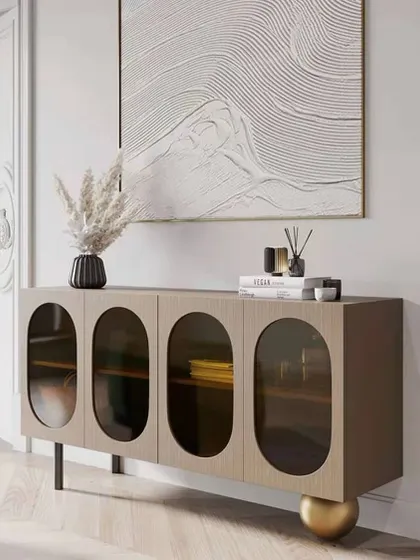The Plisse cabinet, designed to add texture and exquisiteness to your room. Its contrasting veneer surface and doors with oval-shaped glass windows capture the attention, while one leg is a unique, sculptural metal sphere.