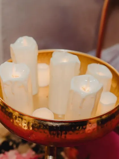 Another detail shot of the candle decor. The warm glow of the candles, set in a hammered brass bowl, adds a touch of elegance and romance to the reception setup.