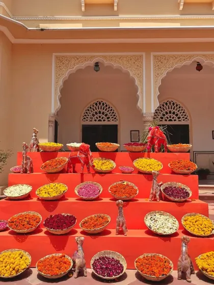 A vibrant display of flower petals in various colors. Arranged in tiers, this setup is both a beautiful decor element and a station for guests to shower the couple with blessings.