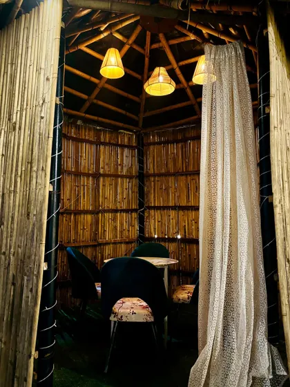 A peek inside one of our rustic bamboo huts. The warm lighting and sheer curtains create an intimate and private dining experience.
