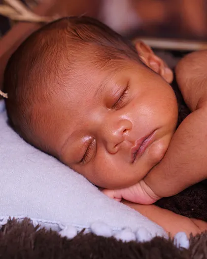 A detailed close-up of the sleeping baby's face. You can see every tiny eyelash and the soft texture of their skin.