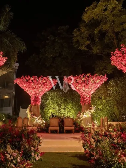We designed this unique mandap to feel like a blooming paradise. Sculptural trees made of vibrant pink florals framed the ceremony space, creating a modern and whimsical setting for the couple to exchange their vows under the open sky.
