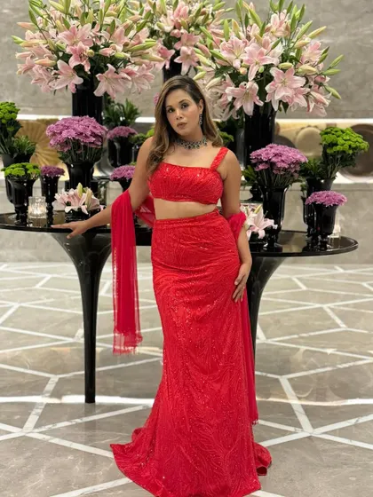 Dressed in a stunning red lehenga, ready for a grand celebration. This look is perfect for a Sangeet or wedding reception where you want to make a bold and beautiful statement.