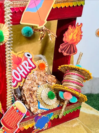 This image captures the essence of Lohri with gajak (peanut brittle), a decorated charkhi (spindle), and bonfire motifs.