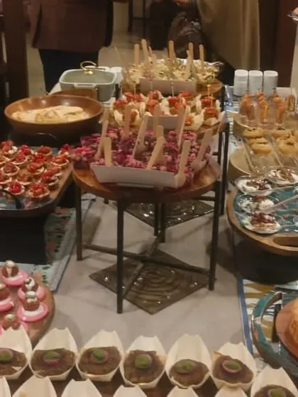 A full view of a high-tea table, showcasing the abundance of options from savory to sweet. The setup is perfect for a relaxed and sophisticated gathering.