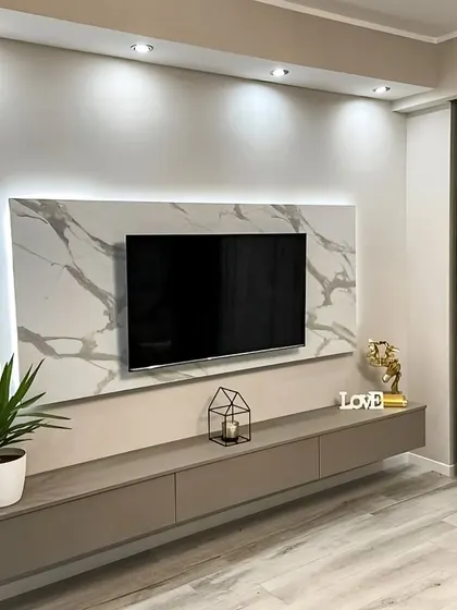 This minimalist floating TV console is paired with a stunning marble-effect wall panel. The soft backlighting adds a touch of elegance and sophistication.