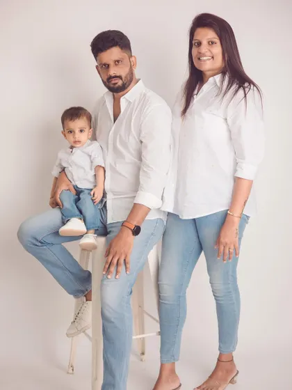 The perfect example of a classic family photo. The coordinated white shirts and denim create a clean, bright, and timeless look against a simple studio backdrop.