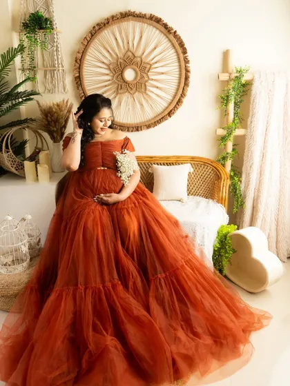 A serene moment in the boho studio setup. The rust-colored gown provides a beautiful contrast against the natural textures of the decor.