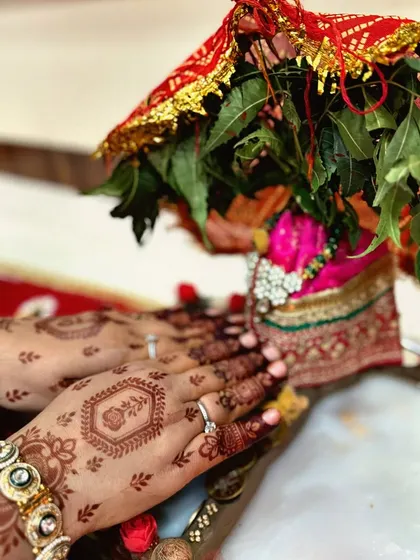 A beautiful shot of hands adorned with simple Teej mehndi, holding a traditional pot. This image captures the essence of the festival,