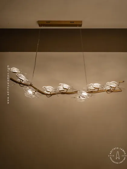 This horizontal chandelier features a flock of glass birds perched on a branch, as if in mid-flight. It's a perfect statement piece for suspension over a long dining table or in a living room, adding a dynamic and natural element.