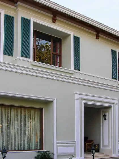 Inspired by London townhouses, this facade uses classic details like decorative shutters and pronounced window moldings to create a sense of rhythm and timeless elegance.