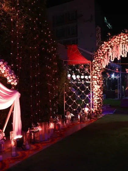 A wider view of the anniversary event entrance, showing a decorated photo corner next to the main floral archway.