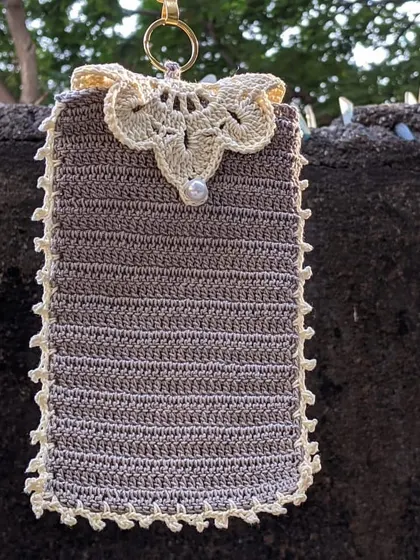 We can add beautiful details like this lace-style flap and a pearl button to our phone pouches. This one is shown in a lovely grey with a cream-colored trim.