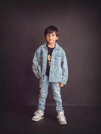 Cool and confident. A classic denim-on-denim look against a dark backdrop creates a timeless and stylish portrait for this little man.