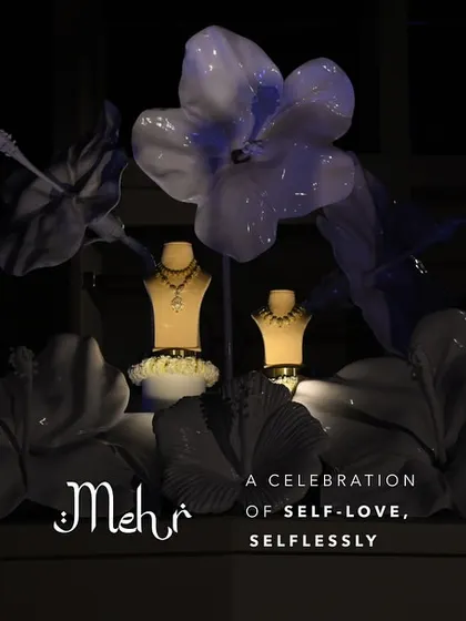 A dramatic nighttime display of the 'Mehr' collection, beautifully illuminated and surrounded by artistic floral installations.