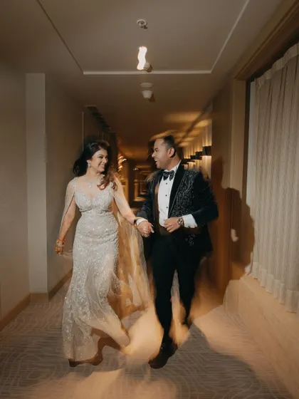 A motion-filled shot of a couple joyfully running down a hotel hallway. This captures the excitement and energy of their engagement night.