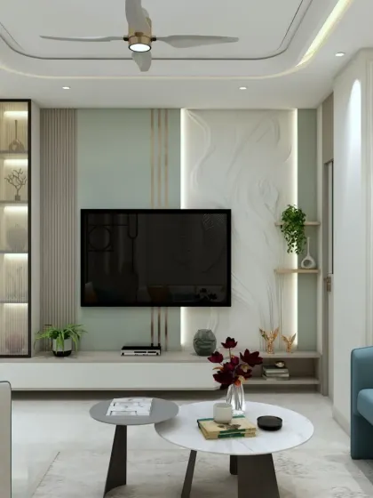 The TV unit in this 3BHK features a beautiful combination of a marble-finish panel and light green textured paint, creating a fresh and modern look.