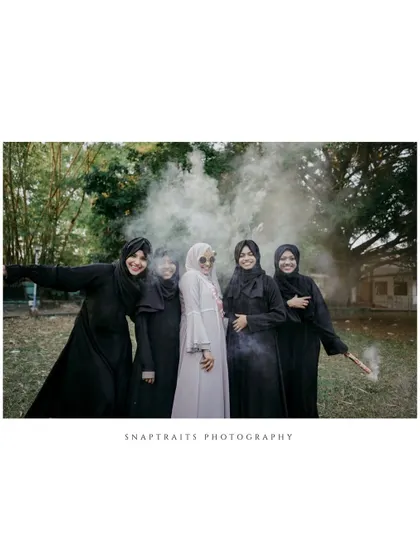 The bride and her bridesmaids celebrate with smoke bombs, creating a fun and dramatic photo opportunity during the bridal shower.