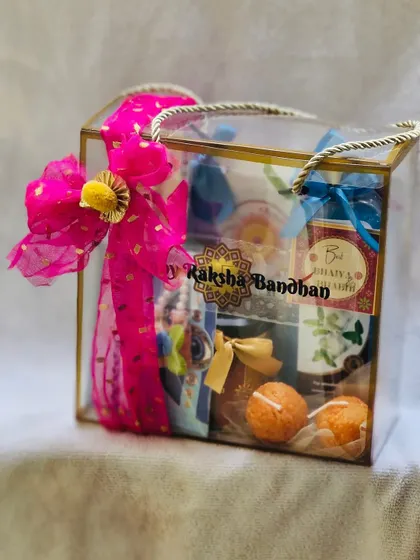 The clear Rakhi gift bag with its vibrant pink bow, showing the festive packaging.