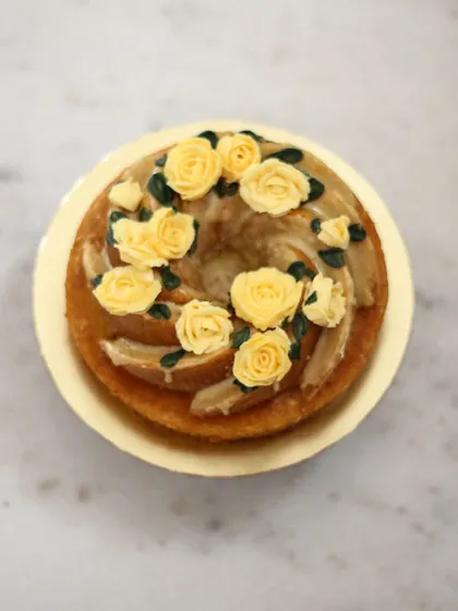 A beautiful swirl bundt cake decorated with delicate yellow buttercream roses. It's a simple cake elevated to something truly special.