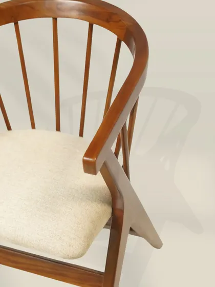 The graceful curve of the armrest and the fanned-out spindles of the backrest create a sense of lightness and sophistication. It's a modern take on a classic Windsor chair design.