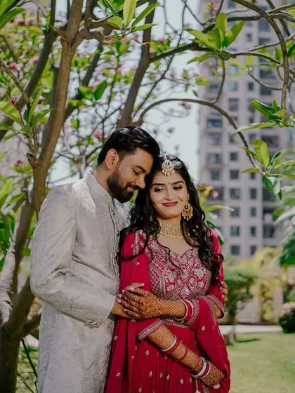 A tender moment as the couple embraces under the shade of a tree. The soft, natural lighting and their gentle interaction create a serene and romantic portrait.