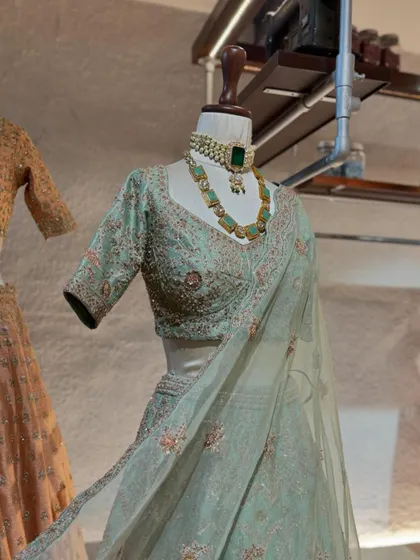 A closer look at the mint green lehenga, paired with a stunning emerald necklace. Accessorizing is key, and I provide personalized recommendations to complete your festive look.