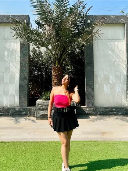 A bright and bold look with a hot pink tube top and a black pleated skirt. This outfit is confident and eye-catching.