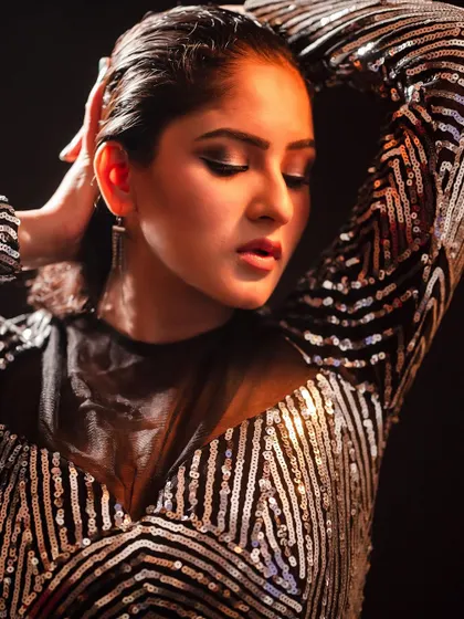 A close-up portrait with a dramatic, high-fashion feel. The wet hair look and intense makeup, combined with the sequined top, create a powerful and edgy editorial shot.