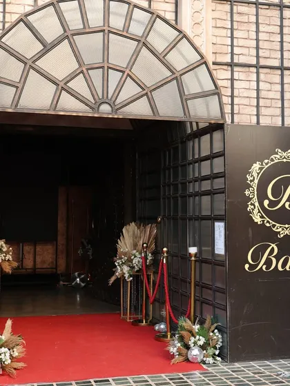 The entrance to the club event, featuring a red carpet and elegant floral arrangements to welcome guests in style.