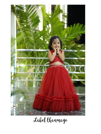 An adorable pose in the red tulle lehenga set. It's designed to be both traditional and fun for parties.