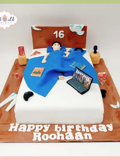 A detailed gaming-themed cake for Roohaan's 16th birthday, depicting him relaxing in bed while playing Fortnite.