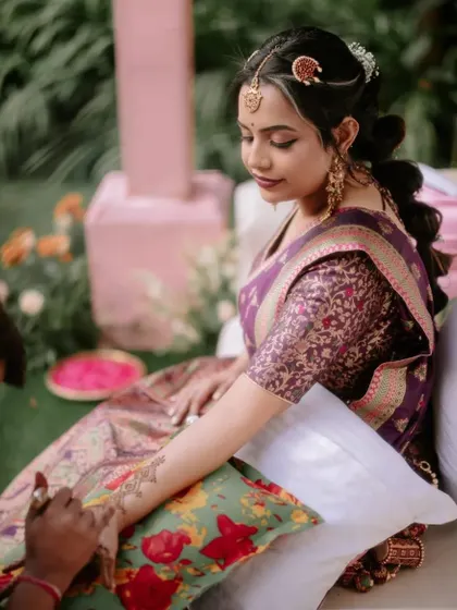 A close-up of the bride's Mehendi application, a quiet and intimate moment amidst the wedding festivities.