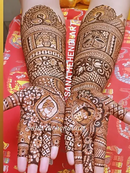 Bride and groom portraits are featured prominently on the palms, surrounded by bands of traditional patterns and peacock figures on the arms.